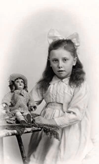 A young girl holding a doll, 20th century