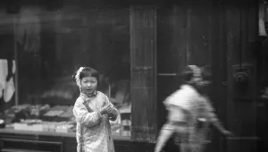 Young girl walking down the street, looking into the camera, Chinatown, San Francisco, c1896-1906. Creator: Arnold Genthe