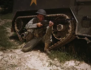 A young soldier of the armored forces holds and sights his Garand rifle... Fort Knox, Ky, 1942. Creator: Alfred T Palmer